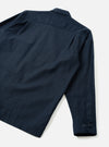 Back view of the Navy Slub Sateen Fatigue Shirt set against a plain off-white background. The image highlights the clean rear seams, straight hem, and subtle slub texture of the dark navy fabric.