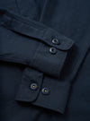 A side profile view of the Navy Slub Sateen Fatigue Shirt displayed against a white studio background. The image highlights the sleeve cuff details, side seam tailoring, and textured cotton fabric.