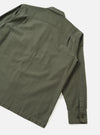 Back view of the Olive Slub Sateen Fatigue Shirt presented against a clean off-white background. The image details the rear shoulder yoke, straight hemline, and durable olive fabric construction.