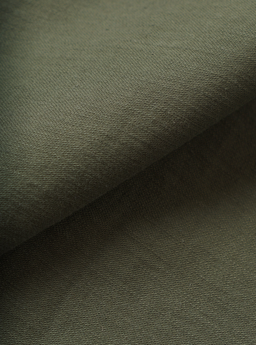 A detailed close-up swatch image showcasing the texture and weave of the Olive Slub Sateen Fatigue Shirt. The filling-frame shot highlights the rich olive green tone and tactile slub cotton fabric.