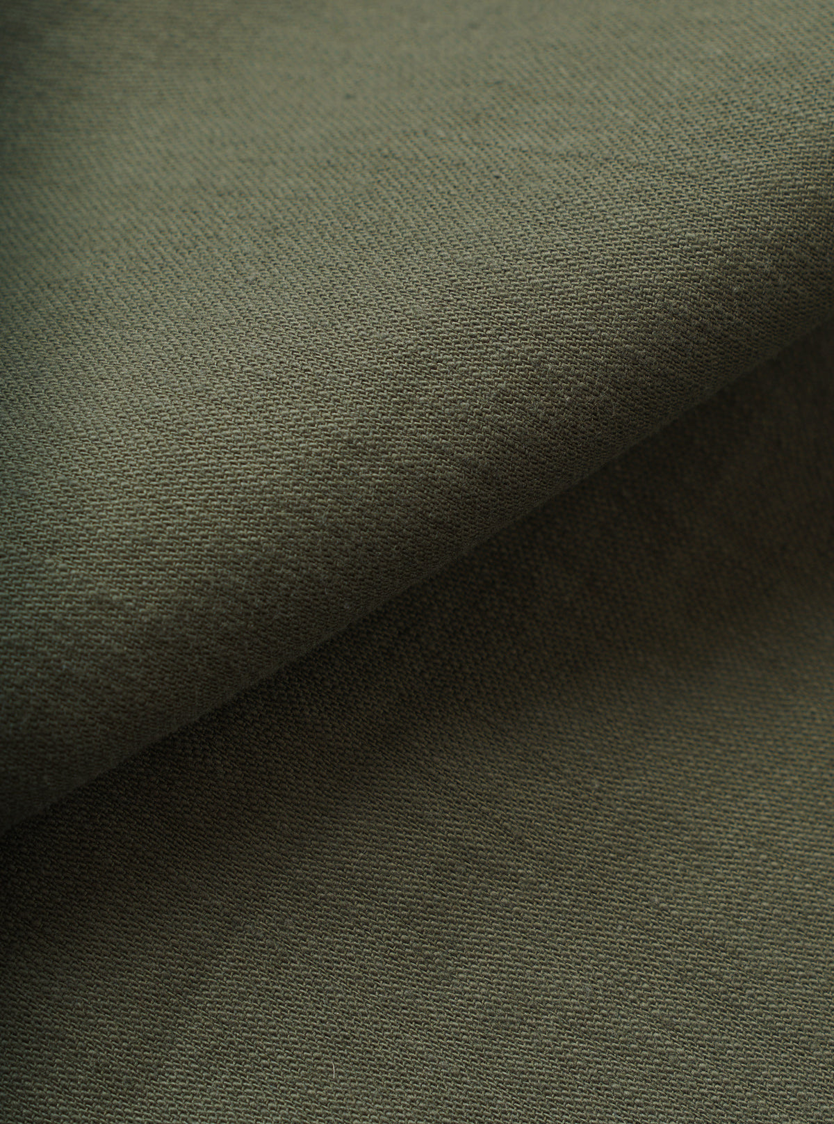 A detailed close-up swatch image showcasing the texture and weave of the Olive Slub Sateen Fatigue Shirt. The filling-frame shot highlights the rich olive green tone and tactile slub cotton fabric.