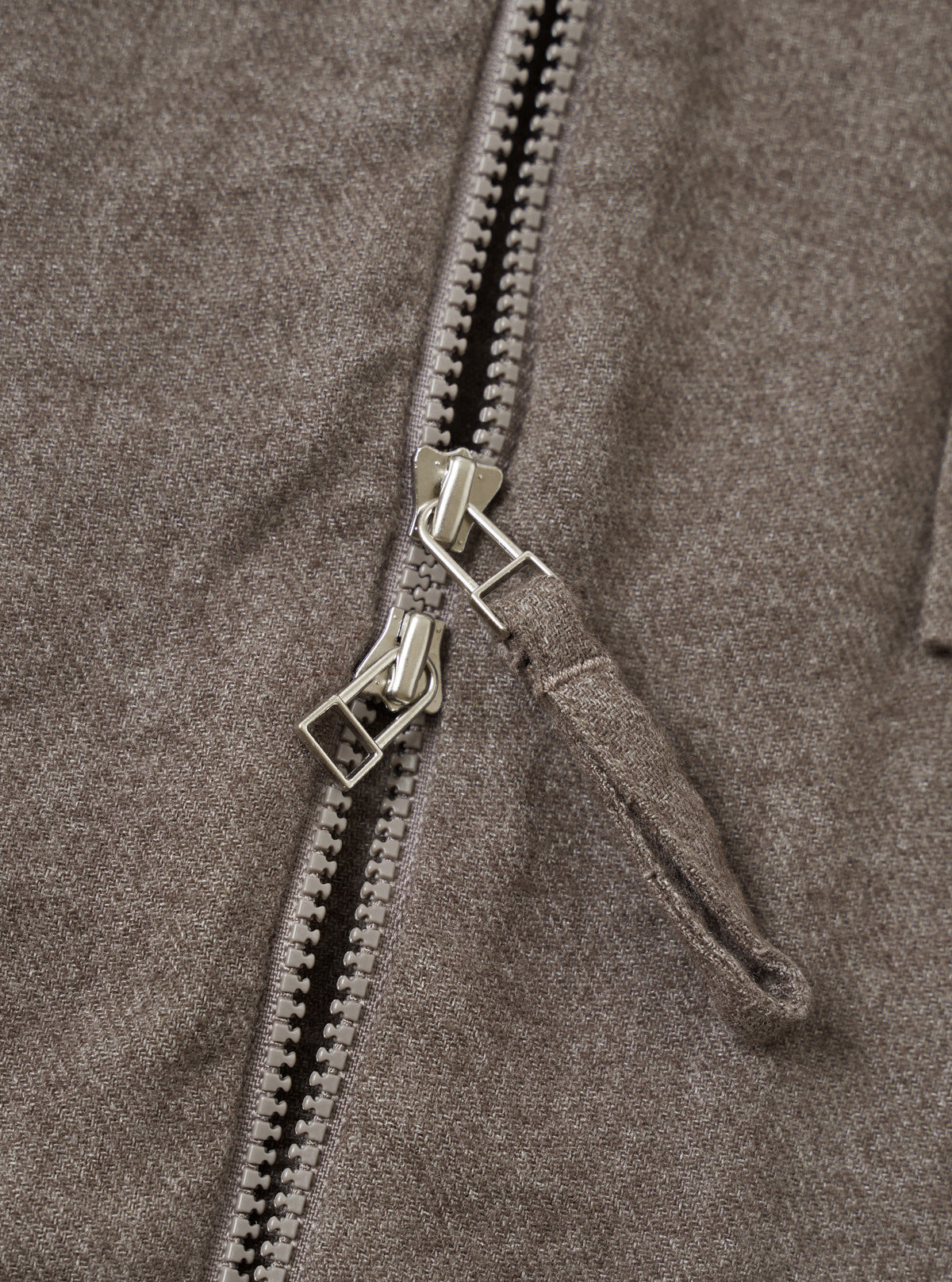 A close-up detail shot of the Brown Monty Cotton Tencel Zip Shirt presented against a plain off-white studio background, showcasing the pointed collar, silver zip closure, and soft fabric texture.