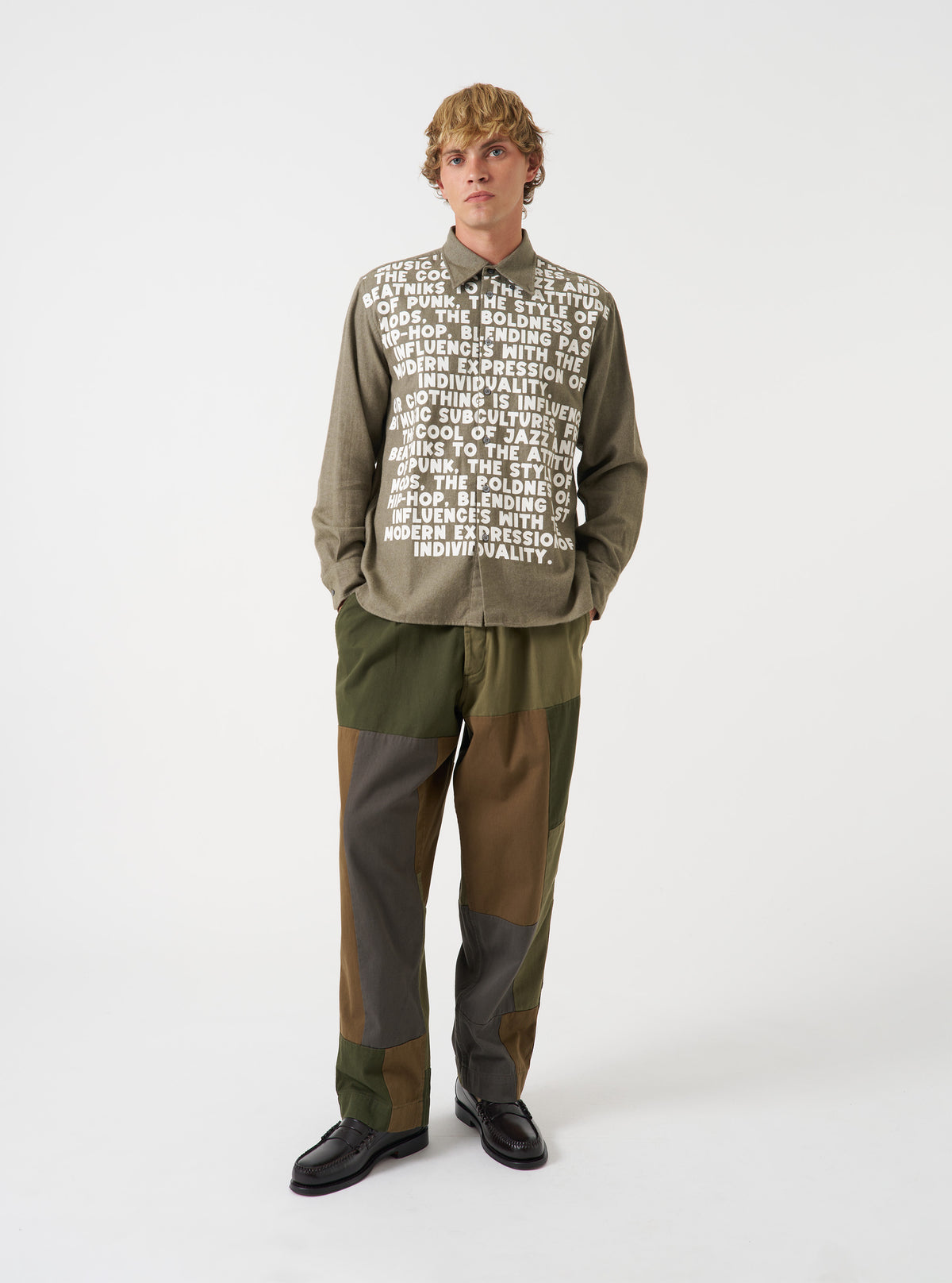 A male model wears the Olive Monty Cotton Tencel Standard Shirt fully buttoned up, standing in a studio setting against a plain background, demonstrating the classic fit and drape.