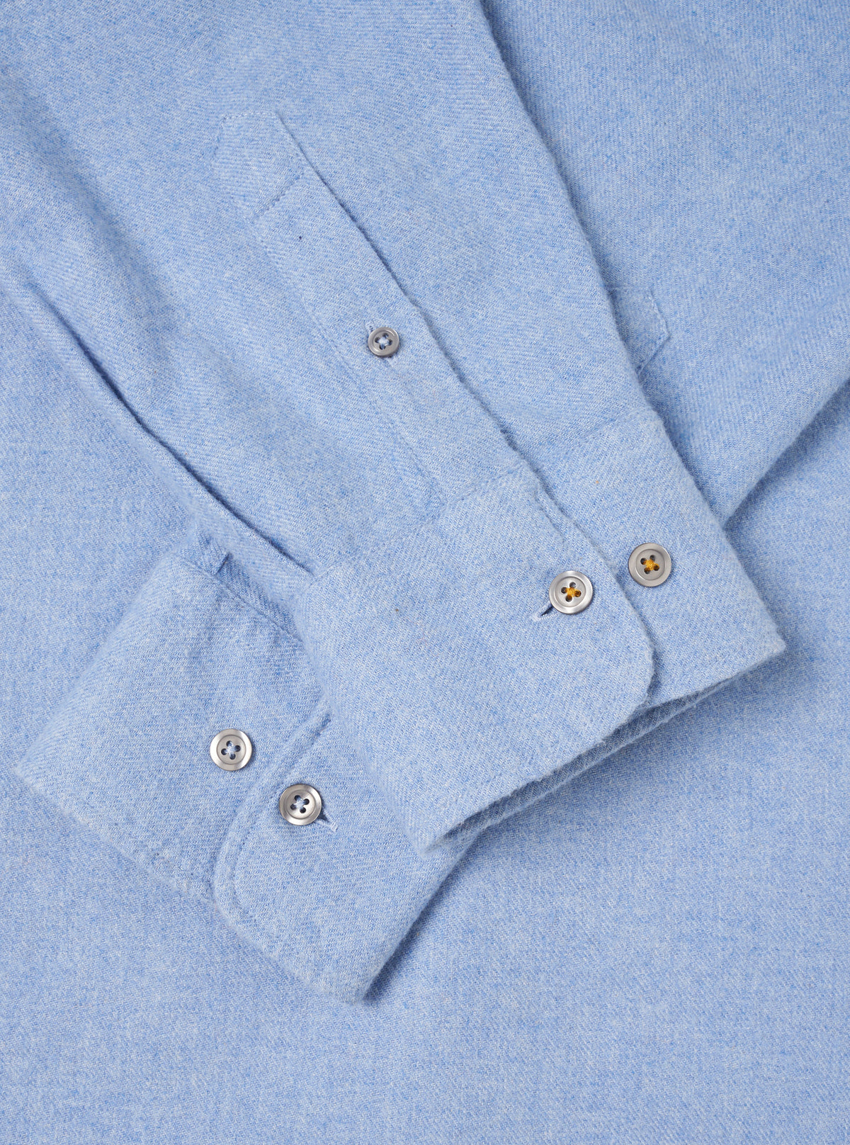 A back view of the Sky Blue Monty Cotton Tencel Standard Shirt presented against a clean off-white background. The shot highlights the smooth back panel, shoulder yoke, neat hemline, and light blue fabric texture.
