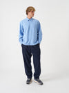 A male model wears the Blue Brushed Flannel Square Pocket Shirt against a plain studio background. The front shot emphasizes the classic collar, front button closure, and square chest pockets on the textured fabric.
