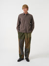 A male model stands against a plain off-white studio background wearing the Brown Brushed Flannel Square Pocket Shirt. The front-facing image highlights the buttoned placket, classic collar, and square chest pockets.