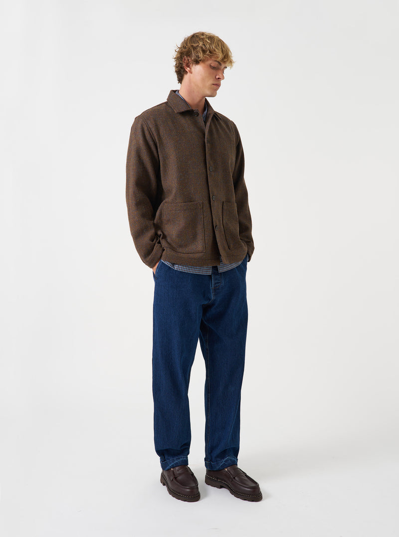 A male model wears the Brown Harris Tweed Easy Jacket paired with trousers, standing against a neutral studio backdrop. The front-facing shot showcases the fit, button closures, and tailored design.
