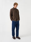 A male model wears the Brown Harris Tweed Easy Jacket paired with trousers, standing against a neutral studio backdrop. The front-facing shot showcases the fit, button closures, and tailored design.