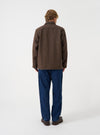 A male model stands in a studio setting wearing the Brown Harris Tweed Easy Jacket in a side profile pose. The picture highlights the shoulder cut, sleeve length, and comfortable textured fit.