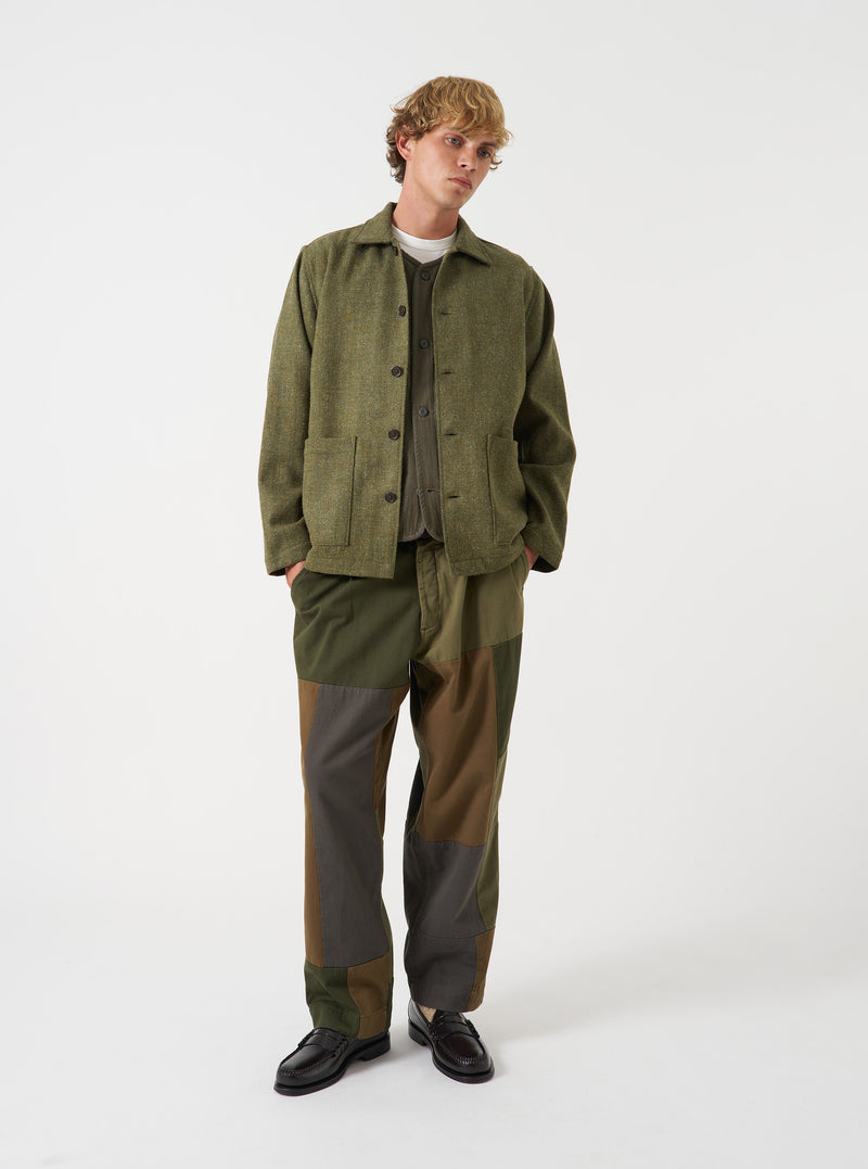 A male model wears the Olive Harris Tweed Easy Jacket buttoned up against a plain studio background. The full-length front view illustrates the relaxed silhouette and overall styling of the garment.