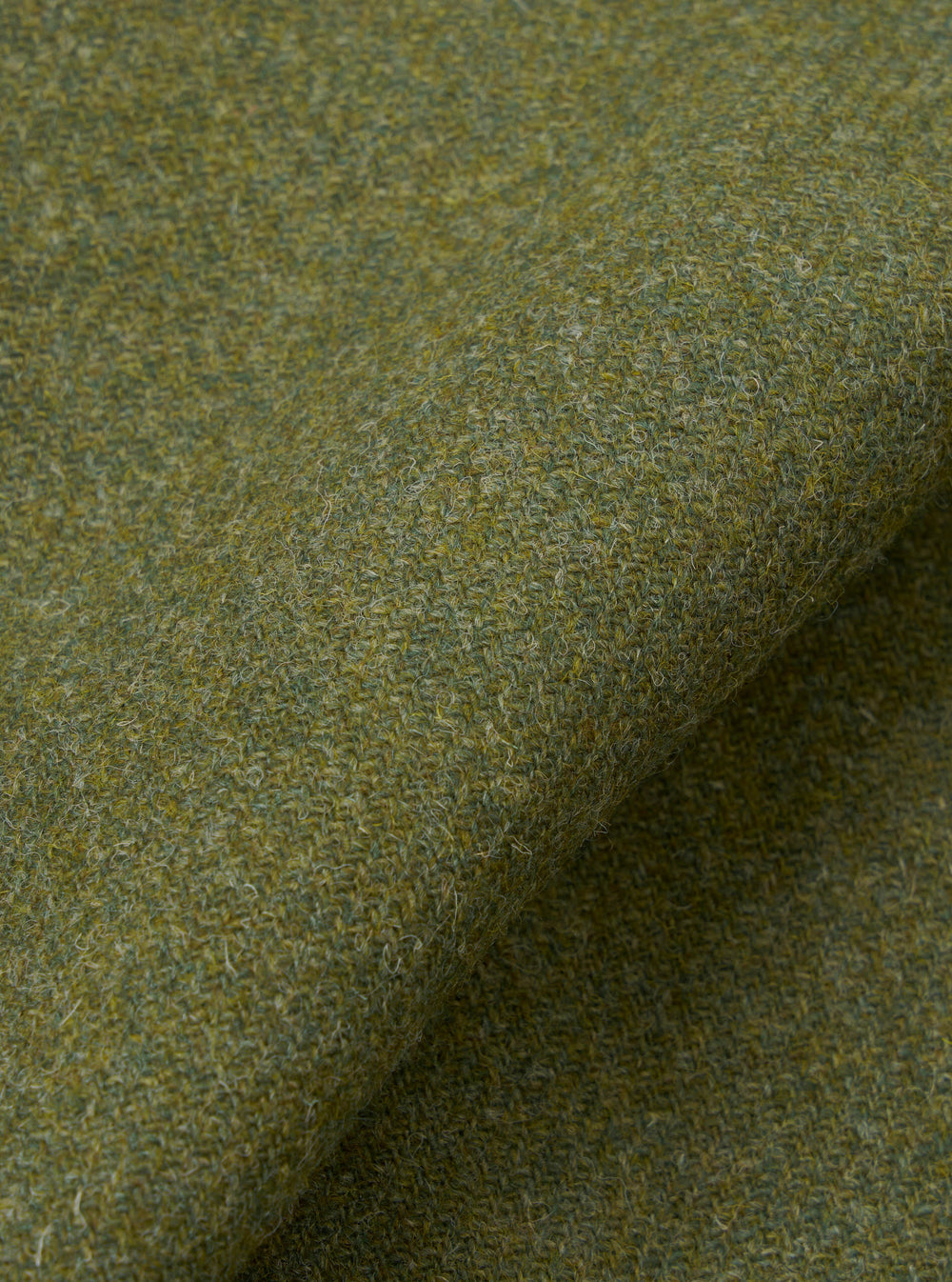 A detailed close-up swatch image showing the material structure of the Olive Harris Tweed Easy Jacket. The frame is filled with the green olive tweed weave, displaying thread variations and quality.