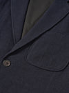 A male model wears the Dark Navy Robin Wool Mix Two Button Jacket styled over a casual outfit against a plain light studio backdrop, demonstrating the relaxed tailor fit, wide lapels, and patch pockets.