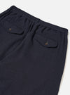 A male model wears the Dark Navy Robin Wool Mix Lindberg Pant with a casual top, standing against a neutral studio backdrop to showcase the slouchy fit, single pleat, and tapered wide leg.