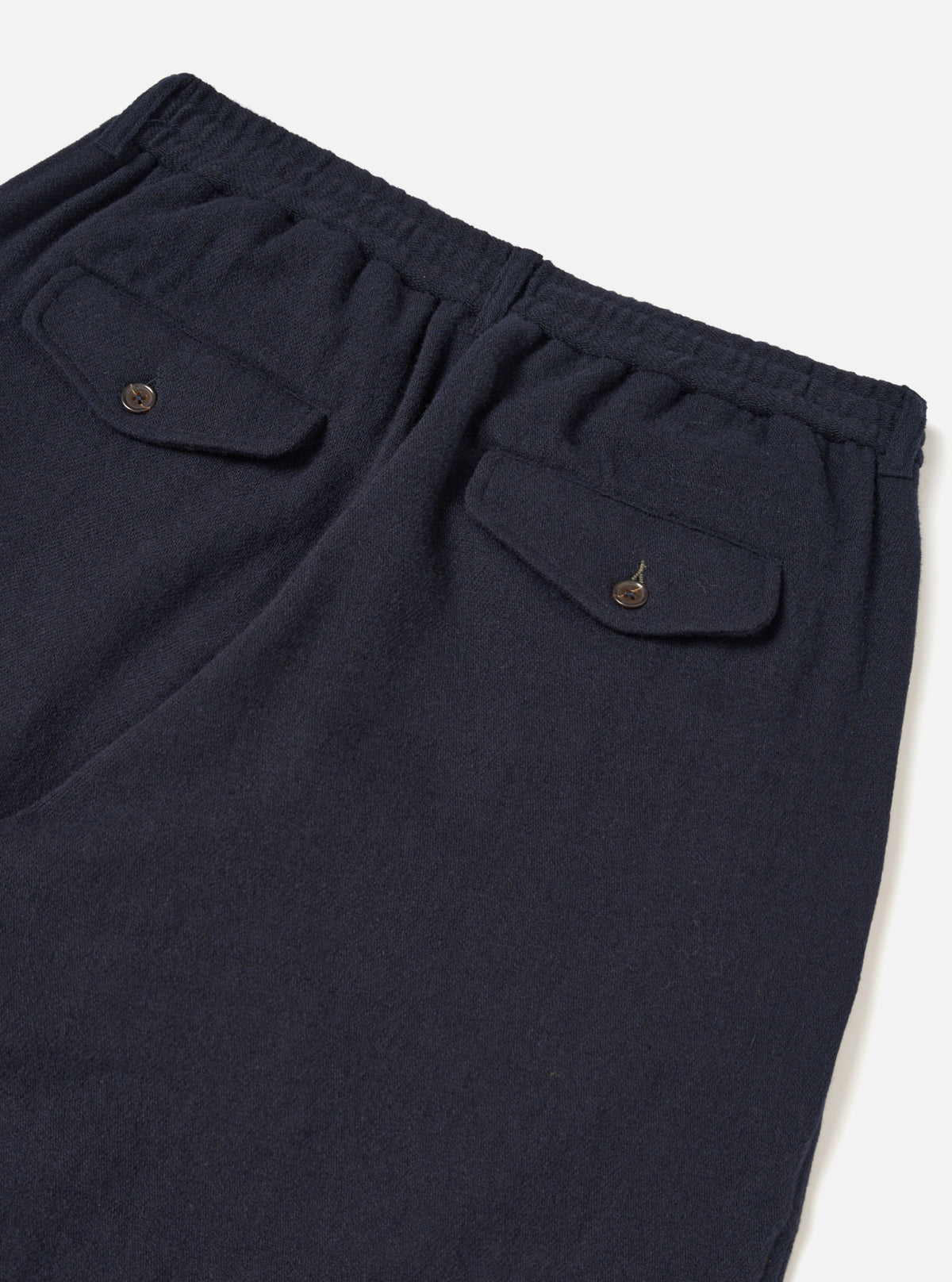 A male model wears the Dark Navy Robin Wool Mix Lindberg Pant with a casual top, standing against a neutral studio backdrop to showcase the slouchy fit, single pleat, and tapered wide leg.