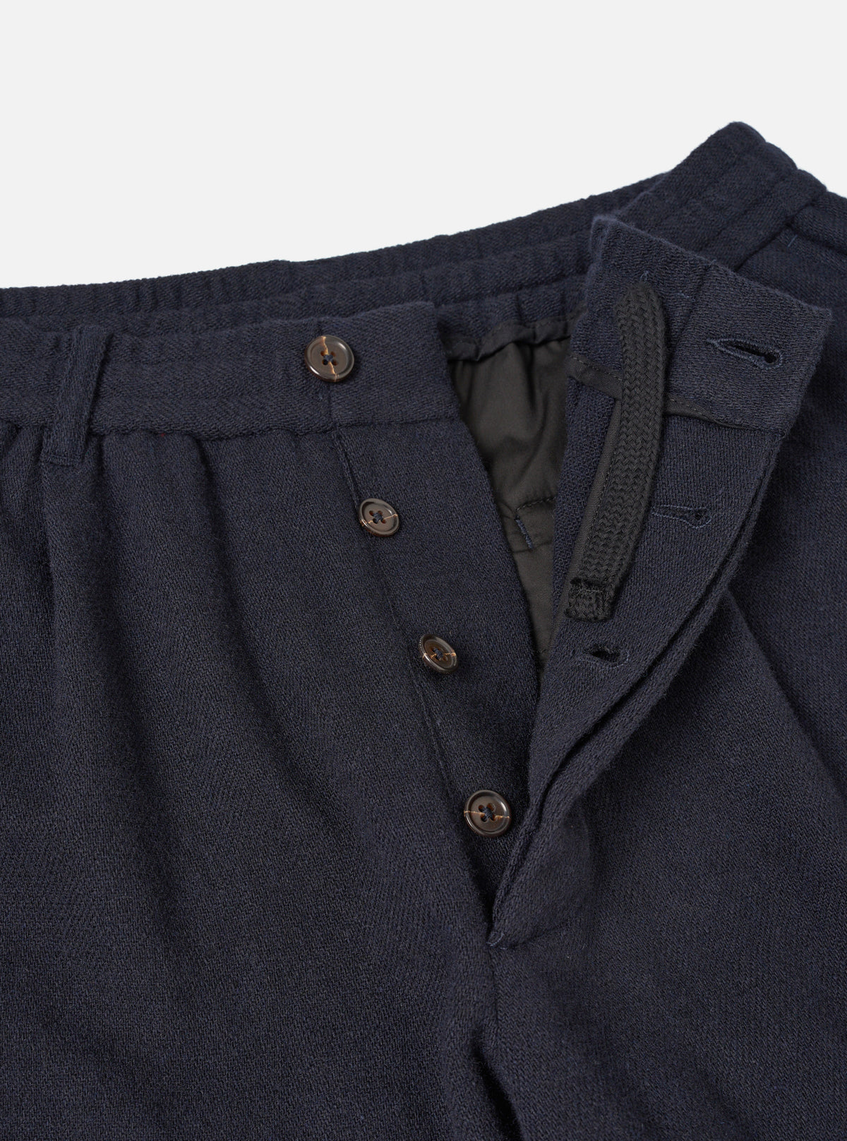 A close-up view of the waist area on the Dark Navy Robin Wool Mix Lindberg Pant against a plain backdrop, highlighting the elasticated drawcord, single pleat detail, and fine fabric weave.