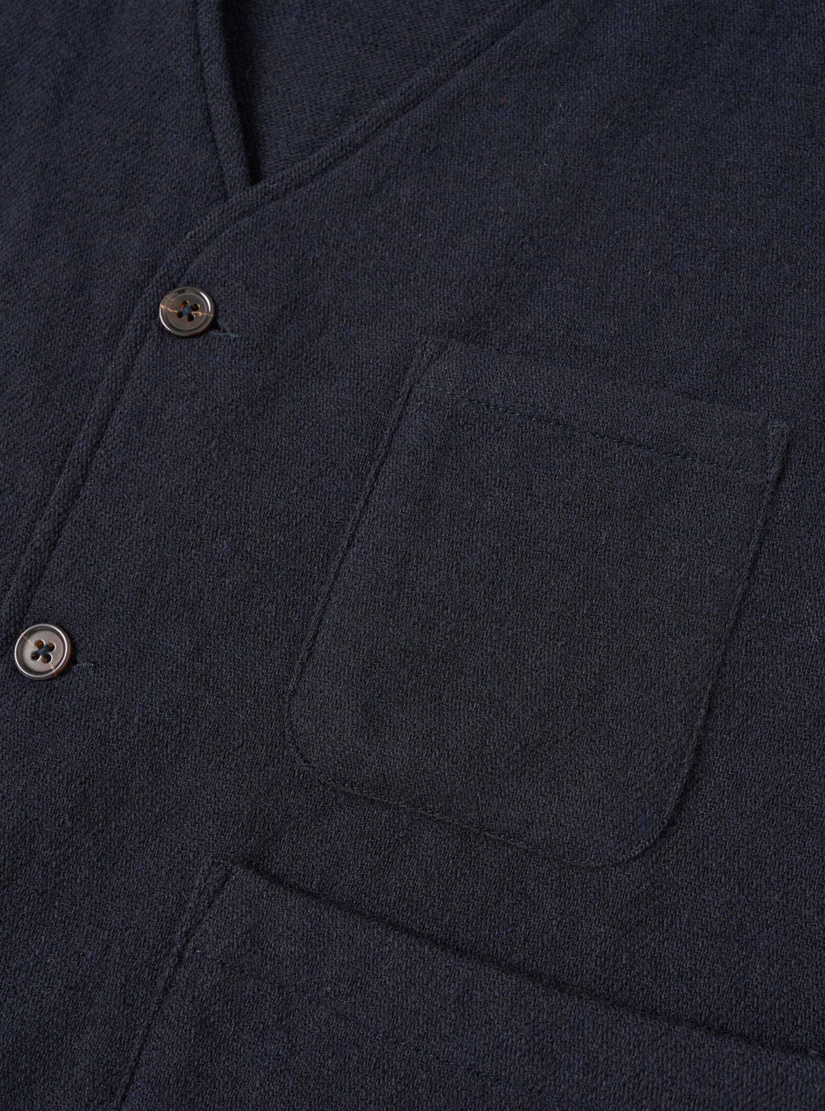 A male model wears the Dark Navy Robin Wool Mix JJ Waistcoat buttoned up over a shirt, standing against a neutral studio backdrop to show the relaxed tailoring and comfortable fit.