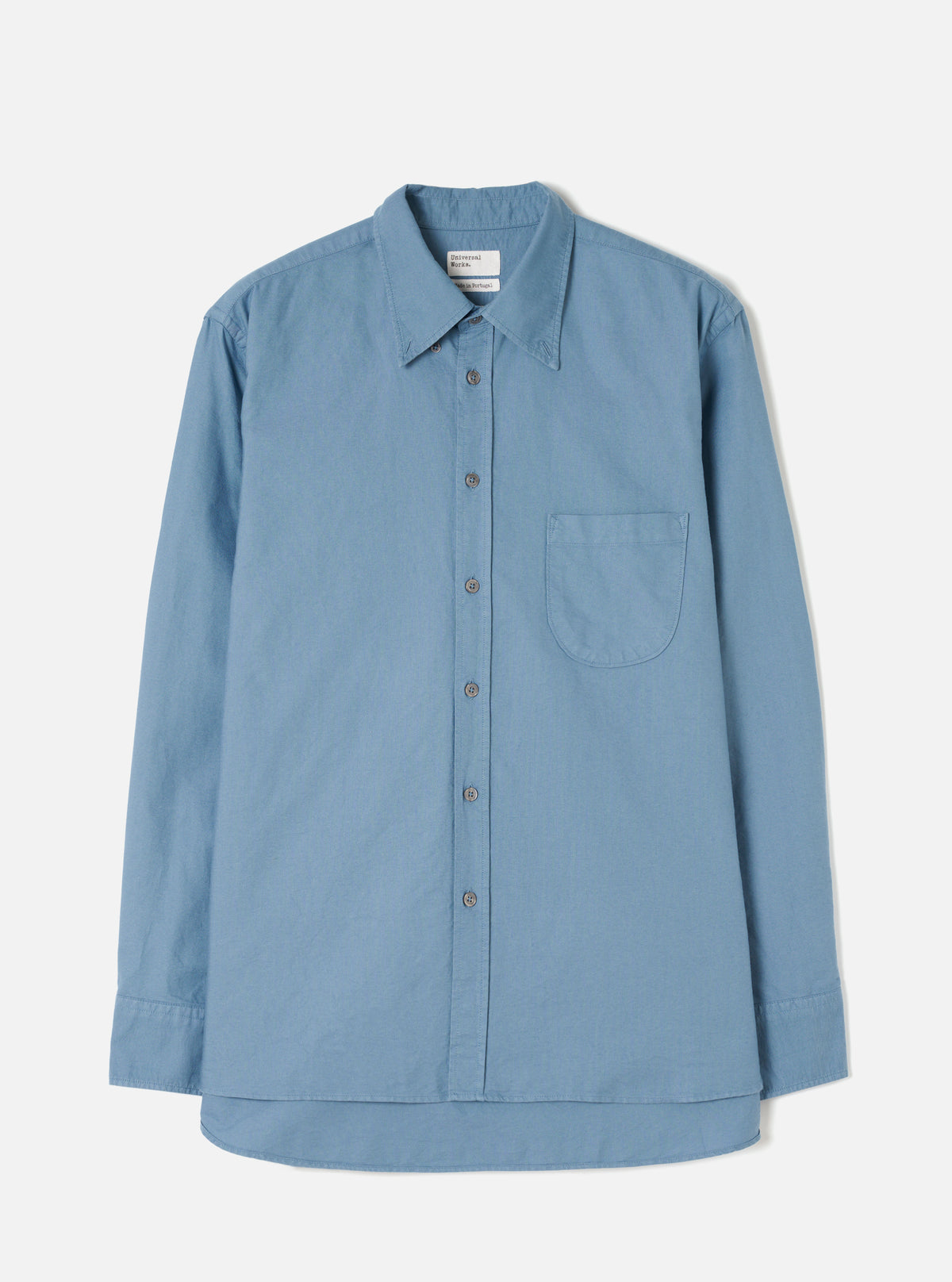 Front view of the Mid Blue R.Oxford Lazy Day Shirt displayed flat against a clean off-white background, highlighting the button-down collar, asymmetric chest pocket, and full button placket.