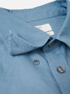 A close-up shot of the Mid Blue R.Oxford Lazy Day Shirt showing the button-down collar, front placket buttons, and asymmetric chest pocket details set against a plain off-white background.