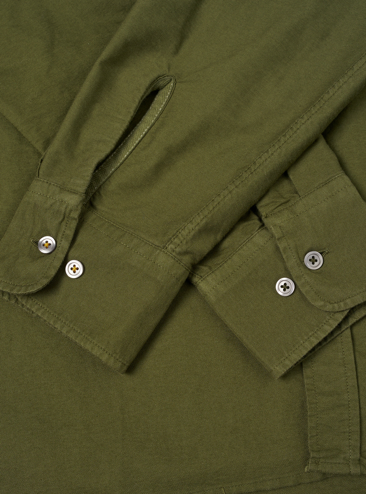 A male model wears the Olive R.Oxford Lazy Day Shirt unbuttoned over a neutral tee, standing against a plain studio backdrop to display the shirt's relaxed silhouette and drape.