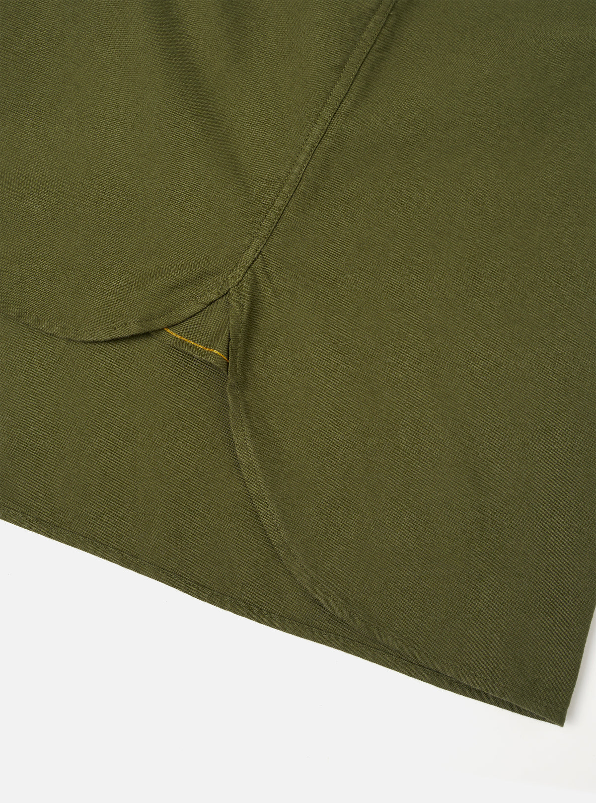 A detailed close-up shot of the Olive R.Oxford Lazy Day Shirt, showing the asymmetric chest pocket, neat stitching, and button-down collar against a plain studio background.