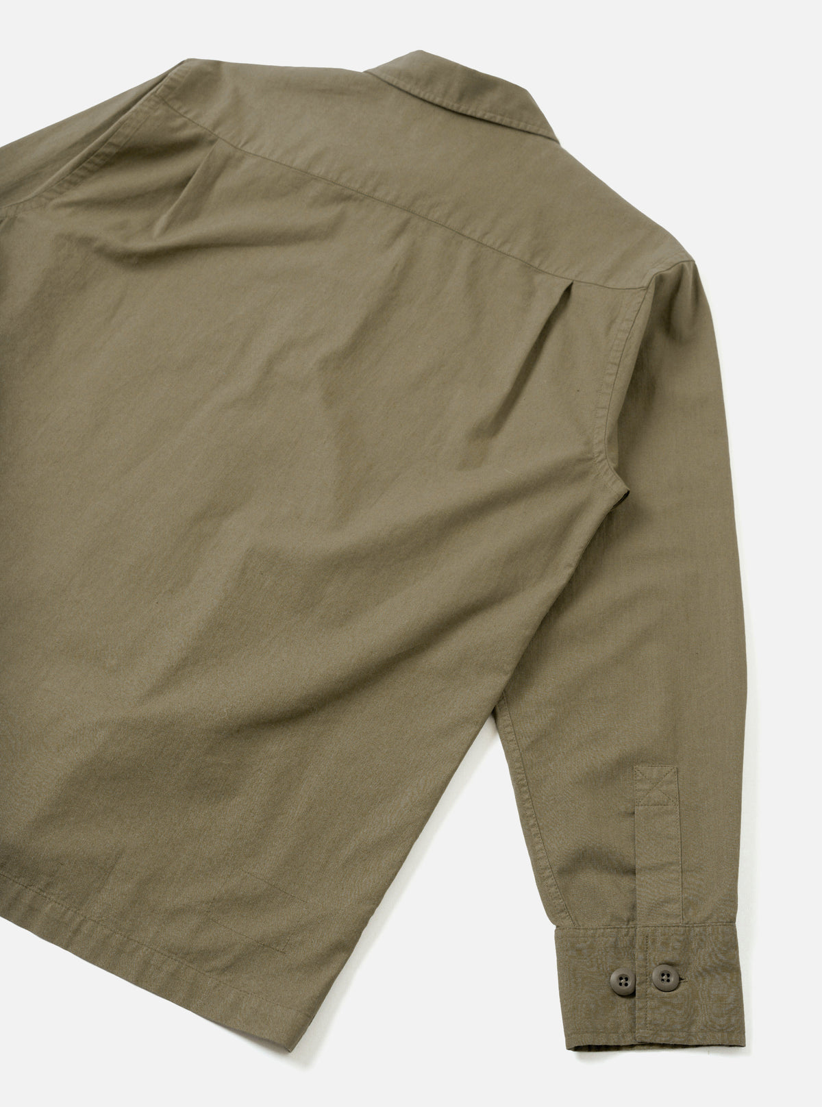 Back view of the Olive Slub Shirting Fatigue Shirt set against a plain white studio background. The image highlights the clean rear panel, hem finishing, and relaxed cut made from olive slub cotton fabric.