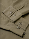 A close-up detail shot of the Olive Slub Shirting Fatigue Shirt against a plain background, highlighting the rich slub texture of the cotton fabric alongside fine stitching around the button closures and chest pocket.