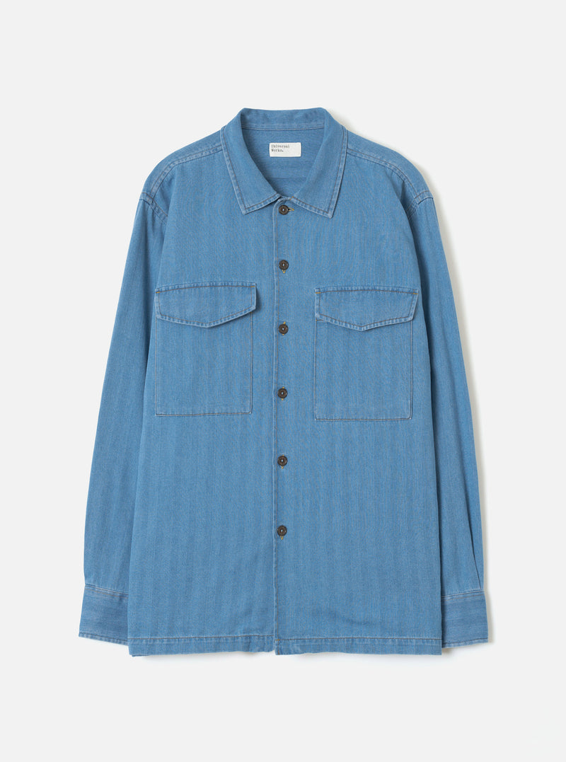 Front view of the Washed Indigo Recycled Herringbone Attendant Shirt presented against a clean white background. The image details the classic collar, front button closures, and utility style pockets in washed indigo cotton.
