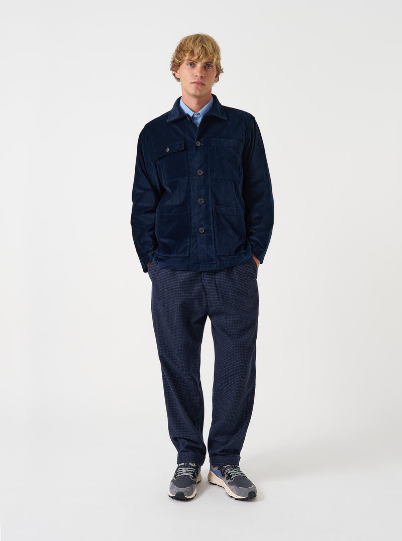 A male model wears the Navy CPH Velvet Dockside overshirt buttoned up against a neutral studio backdrop. The shot showcases the relaxed fit, plush velvet fabric, deep navy color, and front pocket construction clearly.