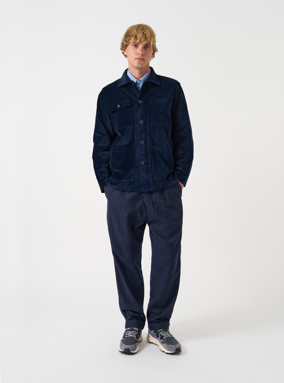 A male model wears the Navy CPH Velvet Dockside overshirt buttoned up against a neutral studio backdrop. The shot showcases the relaxed fit, plush velvet fabric, deep navy color, and front pocket construction clearly.