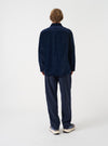 A male model wears the Navy CPH Velvet Dockside overshirt unbuttoned in a side-profile view against a plain studio background. The image details the soft collar, rich navy velvet texture, and comfortable silhouette.