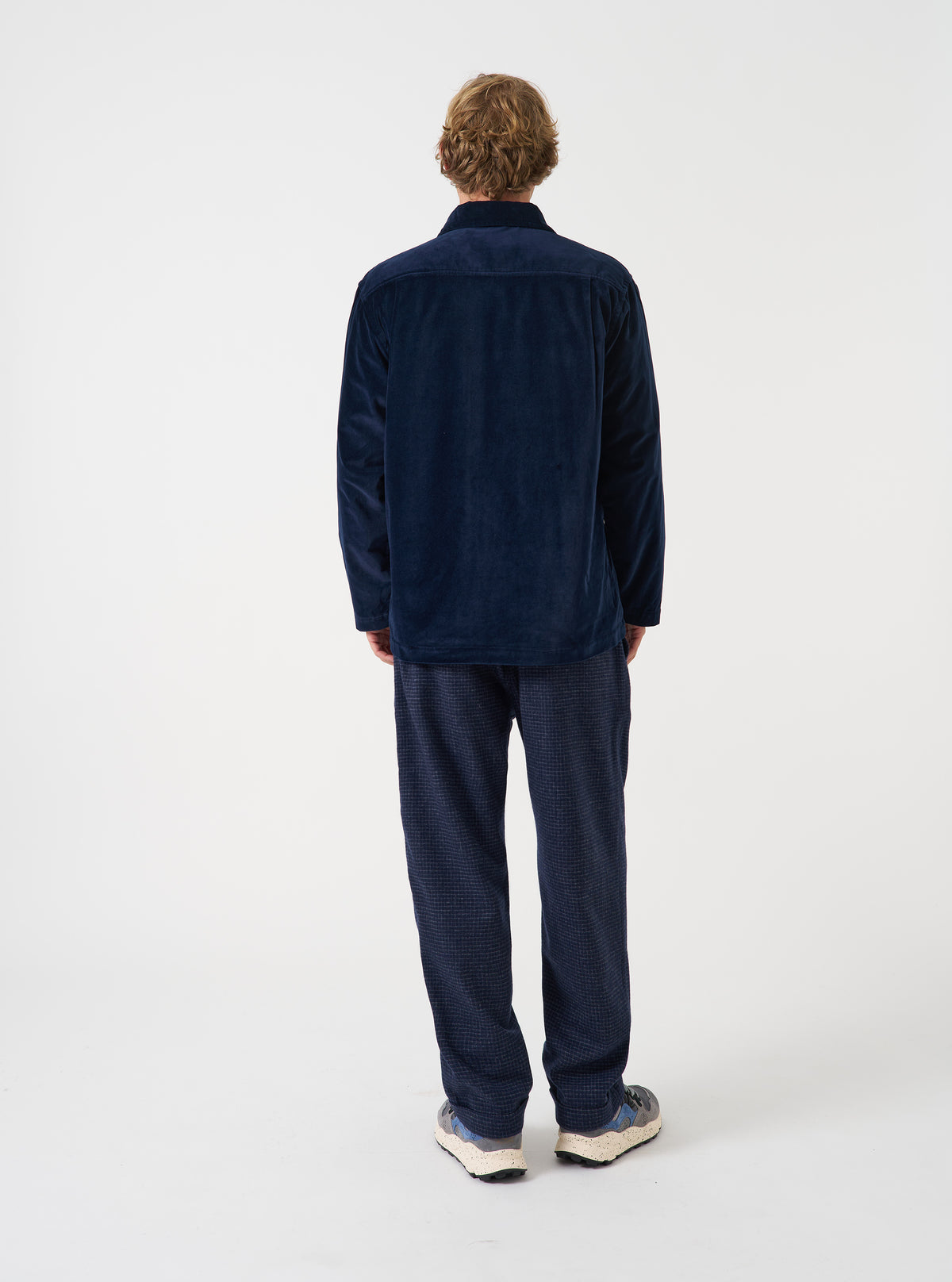 A male model wears the Navy CPH Velvet Dockside overshirt unbuttoned in a side-profile view against a plain studio background. The image details the soft collar, rich navy velvet texture, and comfortable silhouette.