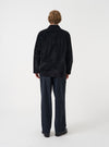 A male model wears the Black CPH Velvet Dockside jacket unbuttoned over a light top, captured in a full-length pose against a neutral studio background. The shot displays the garment's relaxed fit and casual styling.