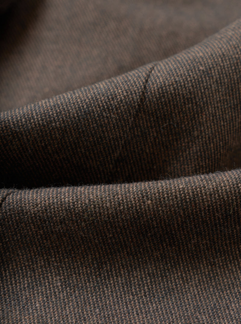 A close-up fabric swatch view showing the intricate weave and flecked texture of the Brown Recycled Italian Tweed Two Button Jacket. The macro image fills the frame to highlight the material's depth and recycled fiber detail.