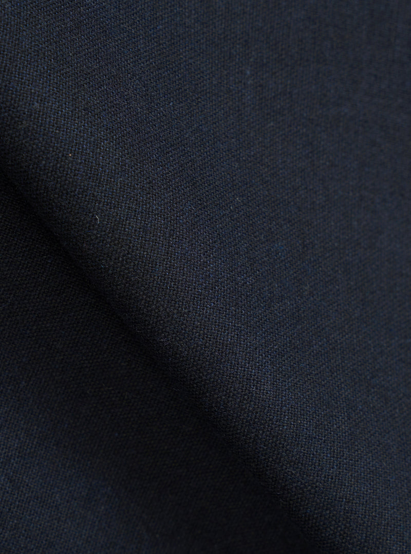 A close-up fabric swatch view revealing the detailed weave and textured finish of the Navy Recycled Italian Tweed Two Button Jacket. The macro image fills the frame, showcasing the dark navy hue and recycled fiber pattern.