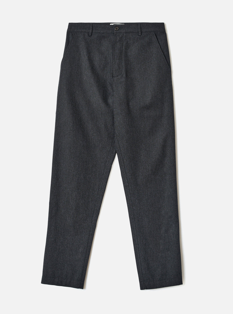 A full-length studio photograph of a model wearing the Charcoal Recycled Italian Tweed Military Chino. The model stands against a plain neutral background, showcasing the dark grey tweed material, straight leg, and tailored cut.