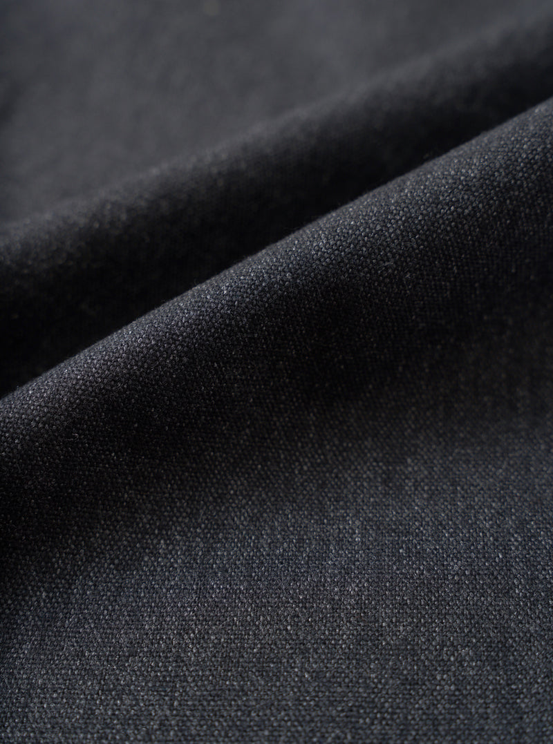 A detailed close-up fabric swatch image of the Charcoal Recycled Italian Tweed Pleated Track Pant on a white background, demonstrating the dark grey recycled wool weave and fine texture.