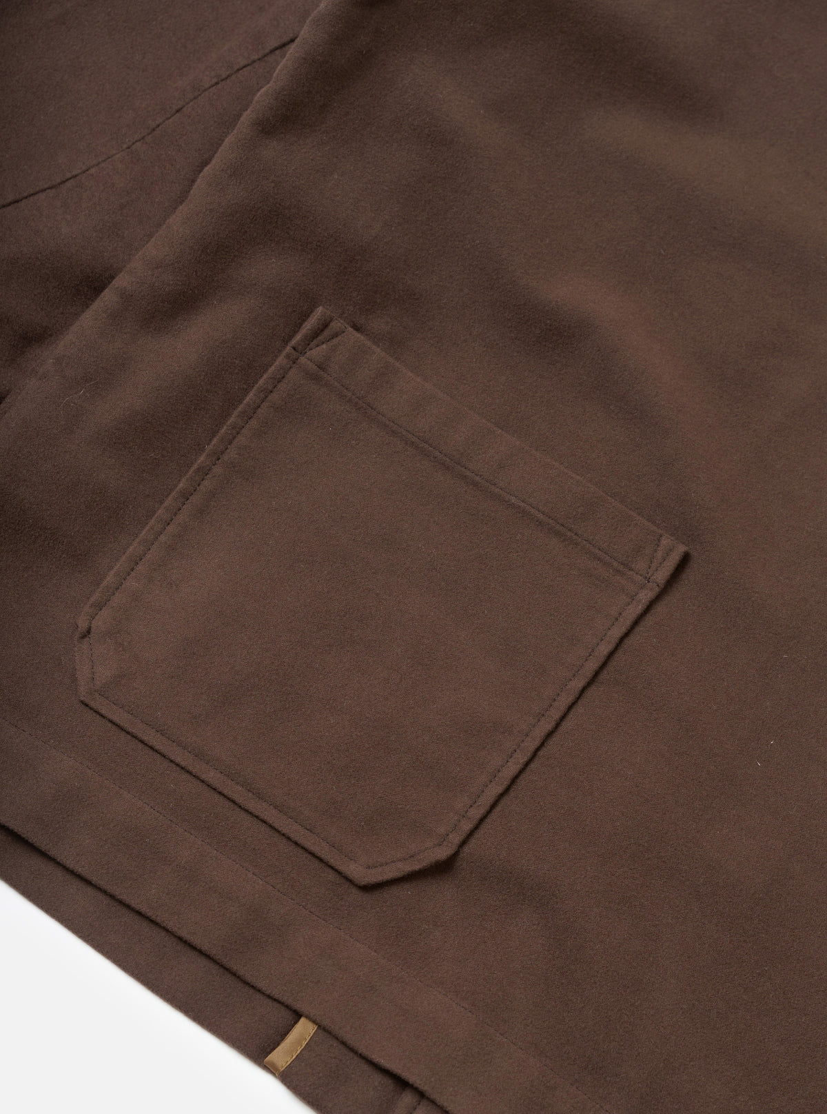 A detailed close-up shot of a model wearing the Brown Comfort Moleskin Ives Jacket, highlighting the collar, button details, and soft, brushed feel of the brown moleskin fabric in a studio setting.