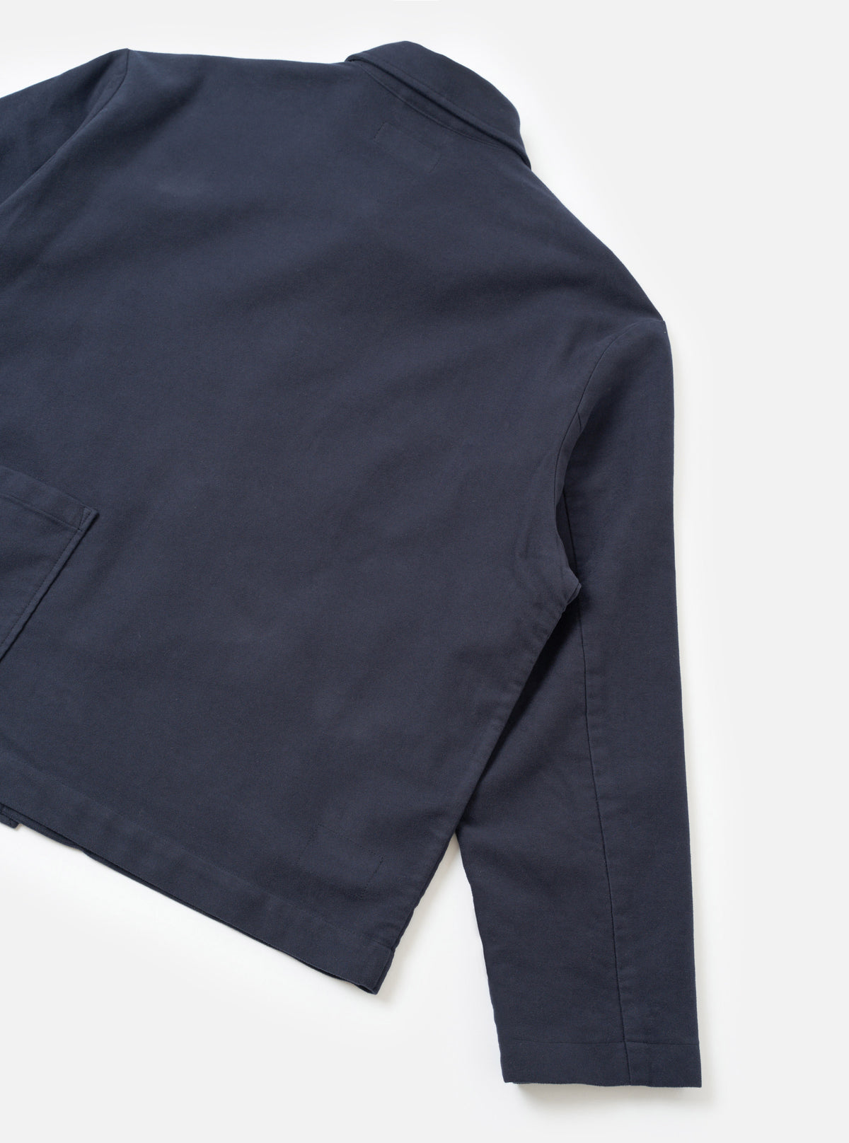 Rear view of the Navy Comfort Moleskin Ives Jacket displayed against a plain white background. The shot highlights the clean back panel, hemline, and soft brushed cotton moleskin texture of the dark blue chore jacket.