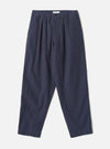 A full front view of the Navy Comfort Moleskin Pleated Track Pant presented on a plain white studio background, displaying the single pleat front, drawstring elastic waistband, and loose tapered trouser shape.