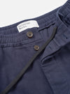 A close-up detail shot of the Navy Comfort Moleskin Pleated Track Pant on a plain white background, showing the waistband, drawstring cord, front single pleat, and deep navy cotton moleskin fabric texture.