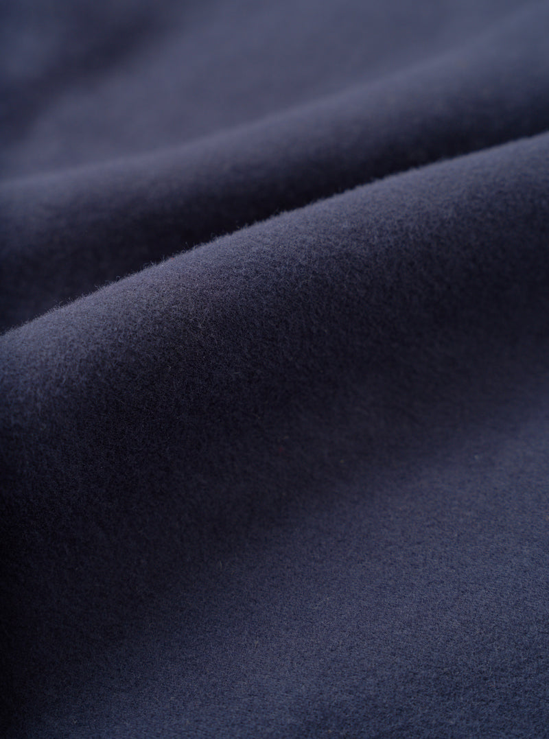 A detailed fabric swatch photo of the Navy Comfort Moleskin Pleated Track Pant on a plain white backdrop, highlighting the soft brushed finish and dense cotton canvas structure in dark navy blue.