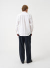 A rear angle photograph of a model wearing the Navy Airline Flannel Oxford Pant in a neutral studio environment, demonstrating the wide silhouette, tailored drape, and back pocket detailing.