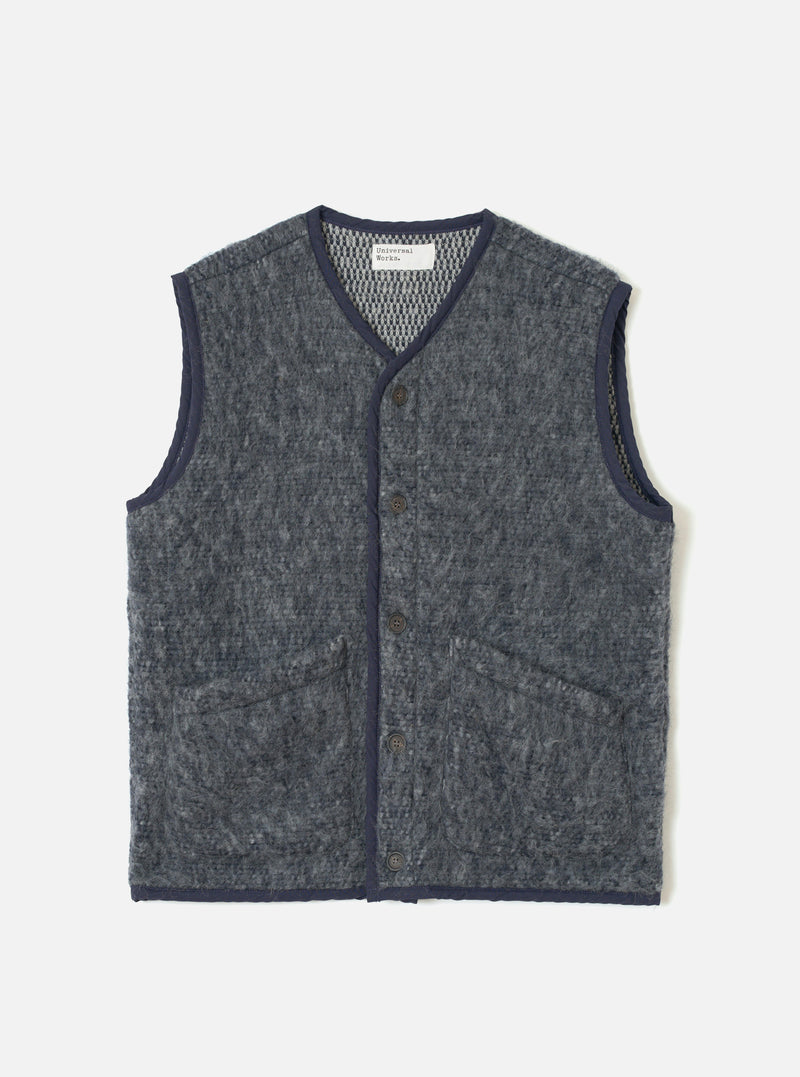 A full-length front view of a model wearing the Navy/Pale Grey Losso Mohair Mix Lancaster Gilet in a studio setting, showcasing its sleeveless design, front button closure, textured knit material, and relaxed fit.