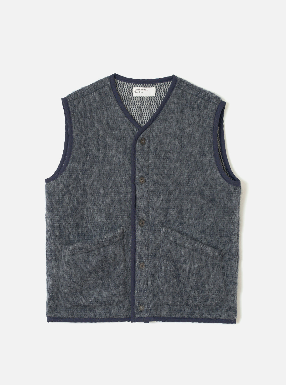 A full-length front view of a model wearing the Navy/Pale Grey Losso Mohair Mix Lancaster Gilet in a studio setting, showcasing its sleeveless design, front button closure, textured knit material, and relaxed fit.