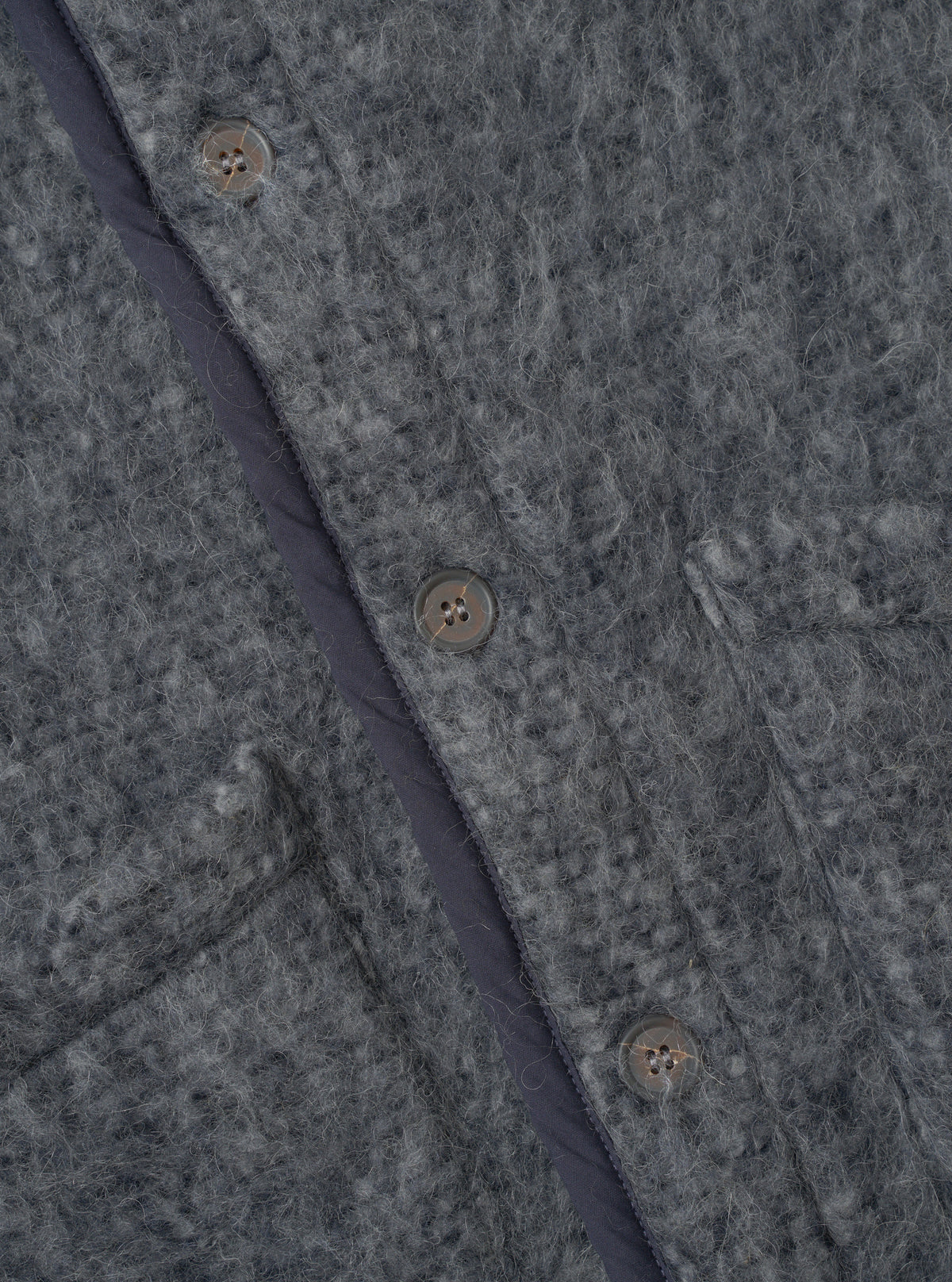 A close-up photograph of a model wearing the Navy/Pale Grey Losso Mohair Mix Lancaster Gilet, focusing on the collar, button closures, patch pocket detail, and fuzzy navy and pale grey mohair blend knit texture.
