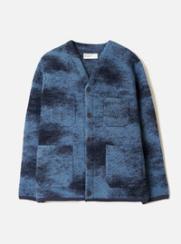 A front view of a model wearing the Blue Cloud Camo Knit Cardigan in a clean studio setting, showcasing the button front closure, cozy wool knit texture, and vibrant blue cloud camouflage pattern across the jacket.