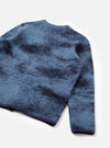 A back view of a model wearing the Blue Cloud Camo Knit Cardigan against a plain background, highlighting the full rear panel, blue cloud camouflage pattern, ribbed hem, and relaxed fit of the knitted garment.