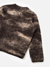 A back view of a model wearing the Brown Cloud Camo Knit Cardigan against a neutral backdrop, showcasing the fit, comfortable shoulders, ribbed hem, and all-over brown cloud camouflage knit pattern.