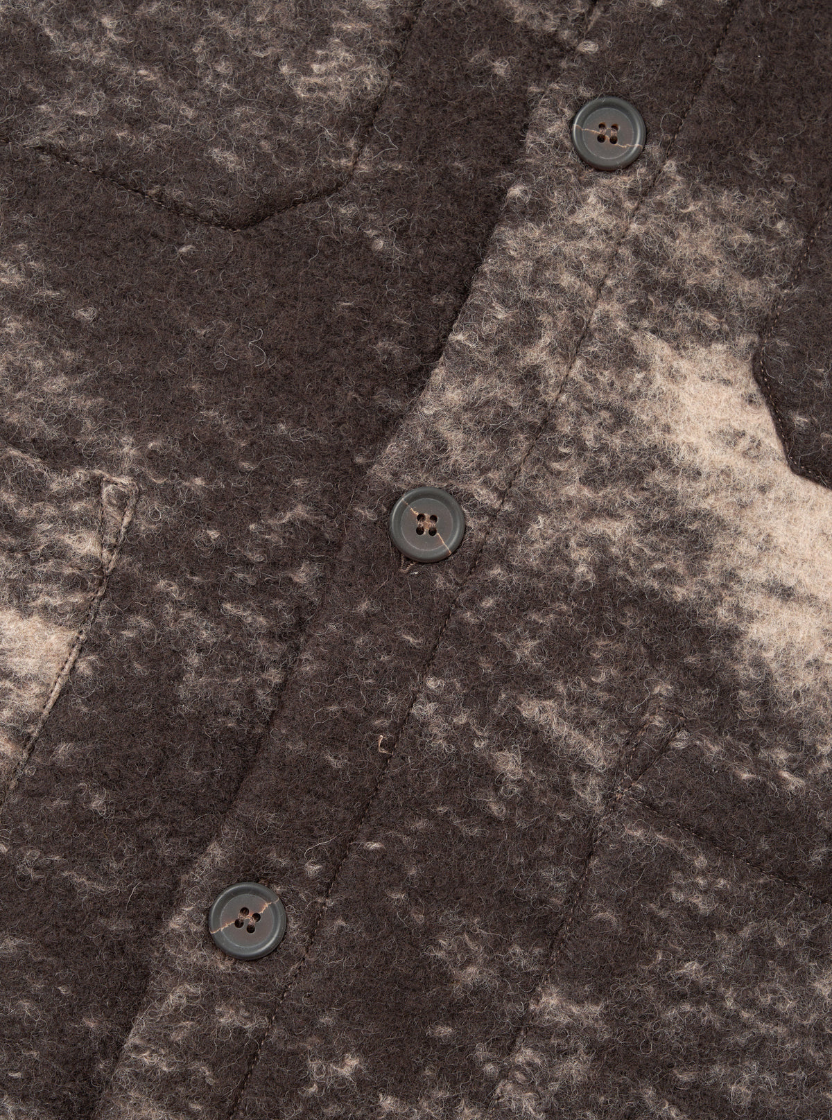A close-up photograph of a model wearing the Brown Cloud Camo Knit Cardigan, highlighting the button placket, ribbed trim, front pocket, and soft textured wool fabric with brown cloud camo pattern.