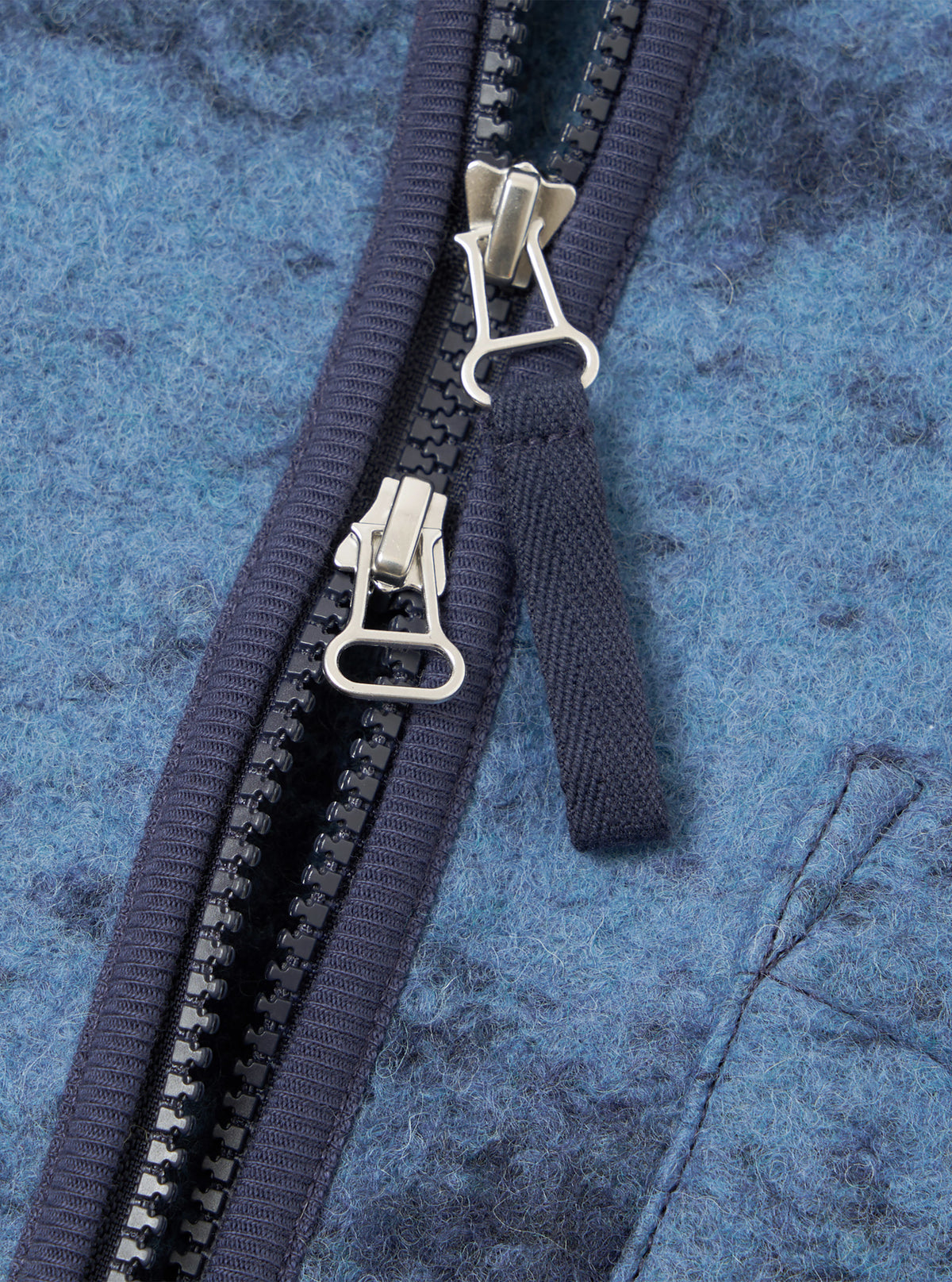 A detailed close-up shot of a model wearing the Blue Cloud Camo Knit Zip Gilet, showcasing the zipper closure, collar detail, front pockets, and soft blue cloud camouflage knit texture.